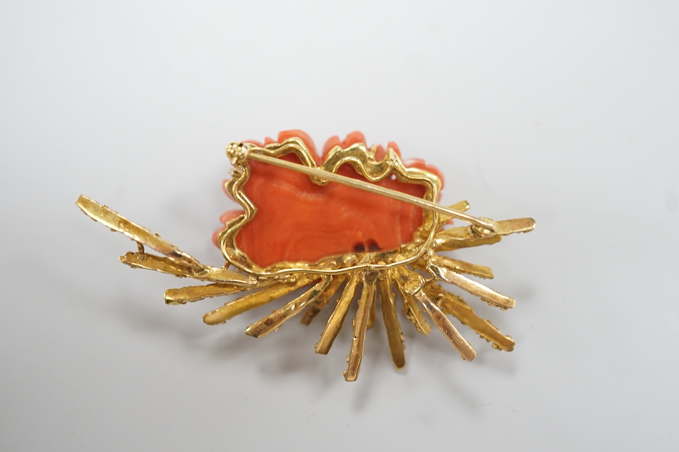 A 1970's? textured 14k yellow metal and carved coral mounted floral spray brooch, 62mm, gross weight 17.1 grams.